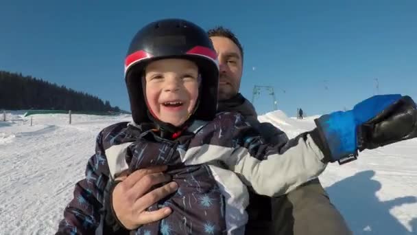 Μικρό αγόρι με τον πατέρα του σε ένα έλκηθρο. — Αρχείο Βίντεο