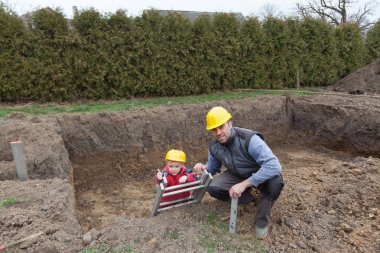 Baba ve oğul bir ev inşa çalışma.