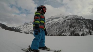 Küçük çocuk ailesiyle Alplerde kayak yapıyor. Babasıyla birlikte bir çocuk. Selfie.