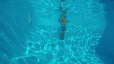 Çocuk oyun Havuzu. Havuzu ve avcılık oyuncaklar batan küçük, sevimli çocuk. Sualtı çekim. Ağır çekim.