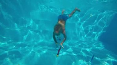 Çocuk oyun Havuzu. Havuzu ve avcılık oyuncaklar batan küçük, sevimli çocuk. Sualtı çekim. Ağır çekim.