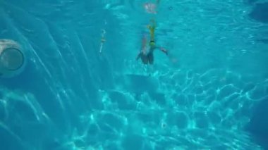 Çocuk oyun Havuzu. Havuzu ve avcılık oyuncaklar batan küçük, sevimli çocuk. Sualtı çekim. Ağır çekim.