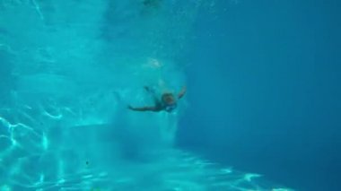 Çocuk oyun Havuzu. Havuzu ve avcılık oyuncaklar batan küçük, sevimli çocuk. Sualtı çekim. Ağır çekim.