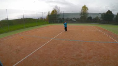Küçük çocuk tenis oynamaya. Bir çocuk için Tenis eğitim. Tenis ders forhend beckend.