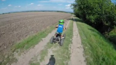Küçük bir çocuk onun elektrik Atv quad sürmek. Bir çocuk bir dörtlü bir yolculuk sahiptir.