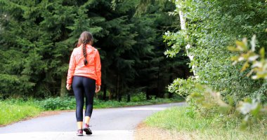 Ormanda yürüyüş yapan genç bir kadın. Hızlı bir yürüyüş. Kız hocalar