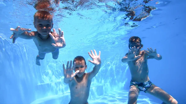 Barn vinkar under vattnet. Pojkar som spelar under vatten. — Stockfoto