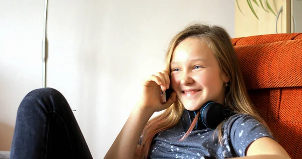 Menina brincando no celular. A criança gasta seu tim livre — Fotografia de Stock