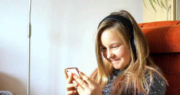 Menina brincando no celular. A criança gasta seu tim livre — Fotografia de Stock