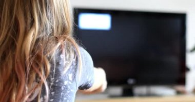 Genç kız programları değiştiriyor. Uzaktan kumandalı çocuk. Sabitlenmiş video.