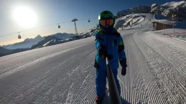Küçük çocuk kayak yapıyor. 6 yaşındaki bir çocuk Alp tatil beldesinde kış tatilinin tadını çıkarıyor. Sabit görüntü. Yavaş çekim. 