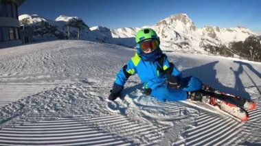 Küçük çocuk kayak yapıyor. 6 yaşındaki bir çocuk Alp tatil beldesinde kış tatilinin tadını çıkarıyor. Sabit görüntü. Yavaş çekim. 