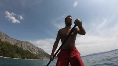 Delikanlı kürek çekiyor.