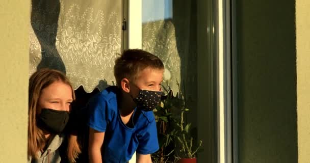 Covid Dzieci Oknie Maskami Chłopiec Dziewczyna Ochroną Twarzy Patrzą Przez — Wideo stockowe