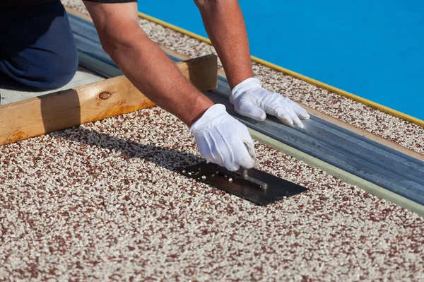 İşçi, taştan bir halı ve reçine koyar.