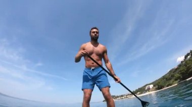 Delikanlı kürek çekiyor. Kürek çeken bir adamın alışılmadık bir görüntüsü. Kamera bir küreğe monte edildi.