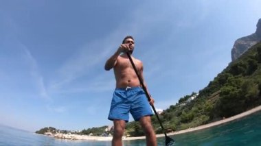 Delikanlı kürek çekiyor. Kürek çeken bir adamın alışılmadık bir görüntüsü. Kamera bir küreğe monte edildi.