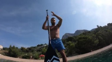 Delikanlı kürek çekiyor. Kürek çeken bir adamın alışılmadık bir görüntüsü. Kamera bir küreğe monte edildi.