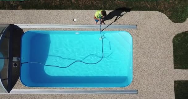 男は水泳プールを吸い掃除する 空中から見た季節の作品 — ストック動画