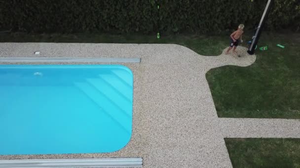 家庭用プールの掃除小さな男の子が吸い スイミングプールを掃除します 空中から見た季節の作品 — ストック動画