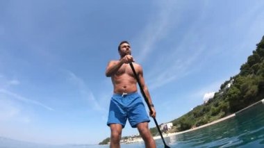 Delikanlı kürek çekiyor. Kürek çeken bir adamın alışılmadık bir görüntüsü. Kamera bir küreğe monte edildi.