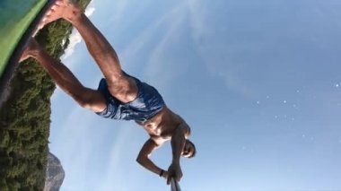 Delikanlı kürek çekiyor. Kürek çeken bir adamın alışılmadık bir görüntüsü. Kamera bir küreğe monte edildi.