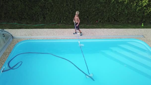 打扫家里的便池 小男孩吸吮并打扫游泳池 从空中角度进行季节性工作 — 图库视频影像