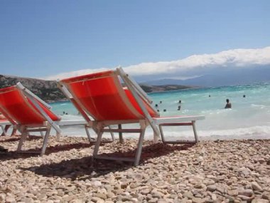 Sahilde, deniz kenarında boş güneş yatakları. Güzel Avrupa beldesi