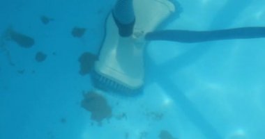 Ev havuzunu temizliyor. Adam emer ve yüzme havuzunu temizler. Havadan bakıldığında mevsimlik iş.