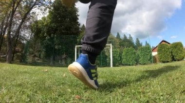 Küçük çocuklar futbol oynuyor. Çocuk kaleciye ateş eder ve kaleye sevinir..