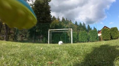 Küçük çocuklar futbol oynuyor. Çocuk kaleciye ateş eder ve kaleye sevinir..