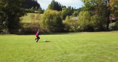 Küçük çocuklar futbol oynuyor. Çocuk kaleciye ateş eder ve kaleye sevinir..