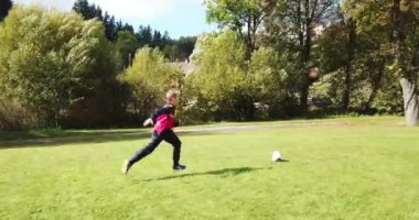 Küçük çocuklar futbol oynuyor. Çocuk kaleciye ateş eder ve kaleye sevinir..