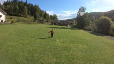 Küçük çocuklar futbol oynuyor. Çocuk kaleciye ateş eder ve kaleye sevinir..