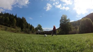 Küçük çocuklar futbol oynuyor. Çocuk kaleciye ateş eder ve kaleye sevinir. Oğlan topla kaleye koşuyor..