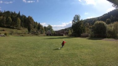 Küçük çocuklar futbol oynuyor. Çocuk kaleciye ateş eder ve kaleye sevinir. Oğlan topla kaleye koşuyor..
