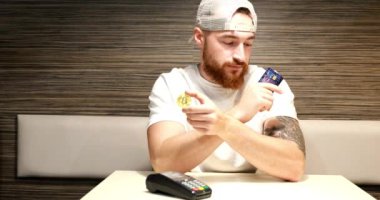 Genç bir çocuk şifreli para ile ödeme yapıyor. Ödeme için dijital para kullanımı. Resimli bitcoin ödemesi.