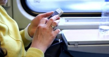 Genç bir kadın elektronik bir kitap okuyup tablet üzerinde çalışıyor..