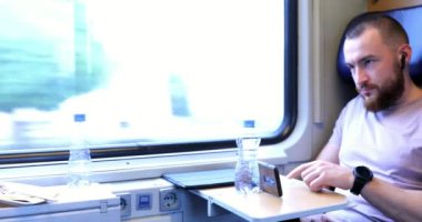 Genç bir kadın kardeşinle birlikte trenle seyahat ediyor. Genç bir kadın elektronik bir kitap okuyup tablet üzerinde çalışıyor..