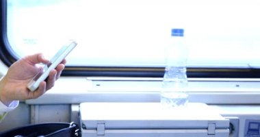 Trenle seyahat eden genç bir adam. Genç bir adam elektronik bir kitap okuyup tablet üzerinde çalışıyor..