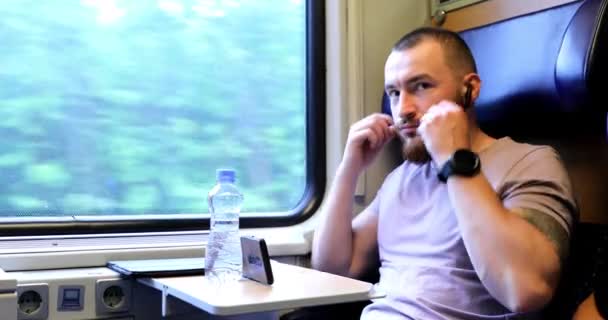 電車で旅行中の若い男電子書籍を読んでタブレットで作業するのに時間がかかっています — ストック動画