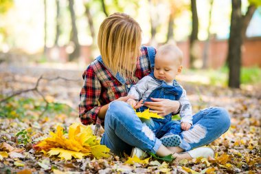 genç anne bebek Park ile sonbaharda oynarken