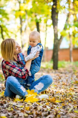 genç anne bebek Park ile sonbaharda oynarken