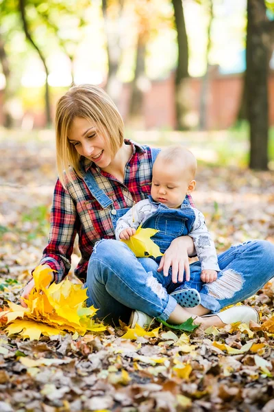 Genç anne bebek Park ile sonbaharda oynarken — Stok fotoğraf