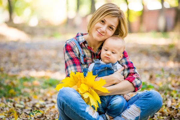 Молода мати грає з дитиною в парку восени — стокове фото