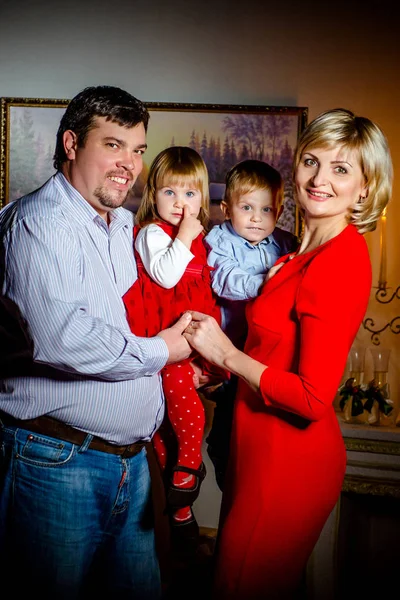 Happy family standing near a Christmas tree in the evening in anticipation of Christmas