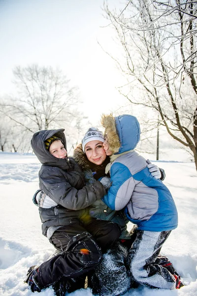 Dois filhos com sua mãe no parque no inverno — Fotografia de Stock