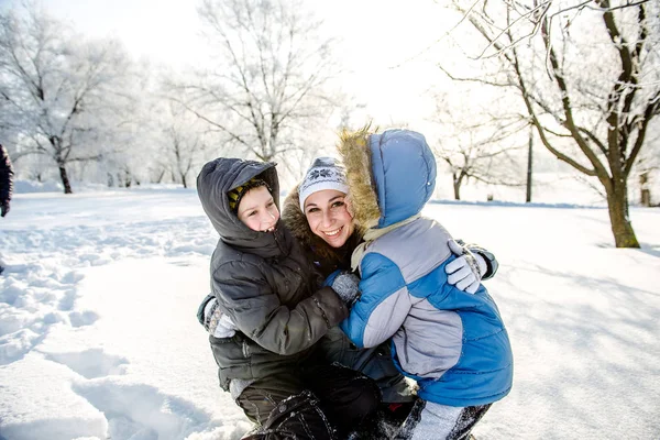 Dos hijos con su madre en el parque en invierno — Foto de Stock