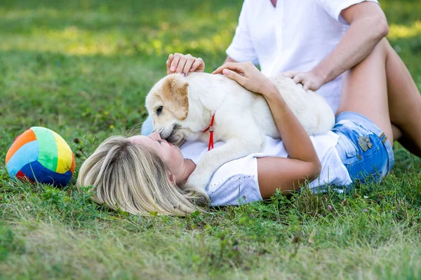 Chica jugando con su cachorro en el parque en primavera — Foto de Stock