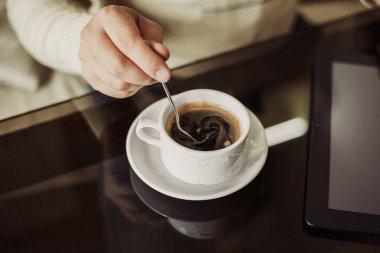 Bir kafede oturan başarılı genç adam bir fincan kahveyle